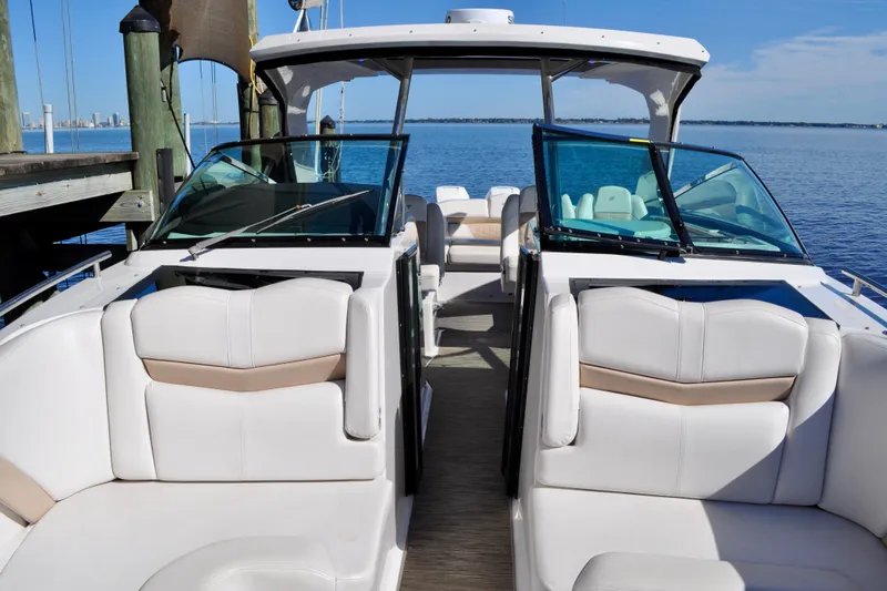  Yacht Photos Pics 2019 Four Winns H350 OB boat interior with white seating, docked by calm blue water.