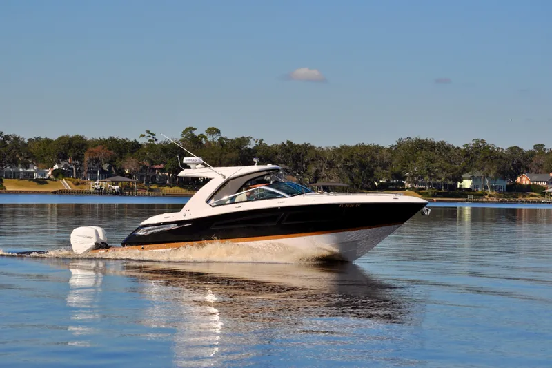  Yacht Photos Pics 2019 Four Winns H350 OB boat cruising on a calm lake with scenic background.