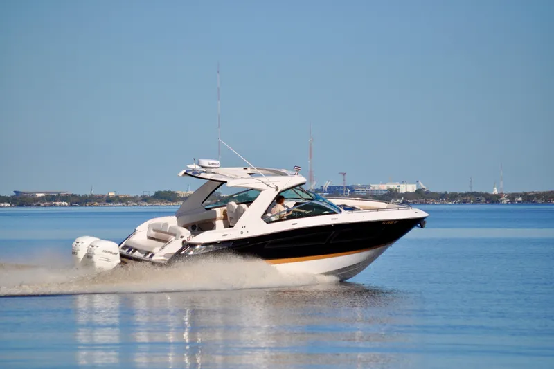  Yacht Photos Pics 2019 Four Winns H350 OB boat cruising on calm water under clear blue sky.