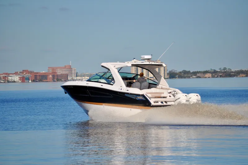 Yacht Photos Pics 2019 Four Winns H350 OB boat cruising on calm water near urban skyline.