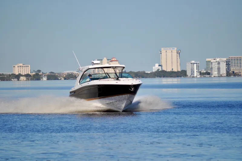  Yacht Photos Pics 2019 Four Winns H350 OB boat cruising on a calm urban waterway.