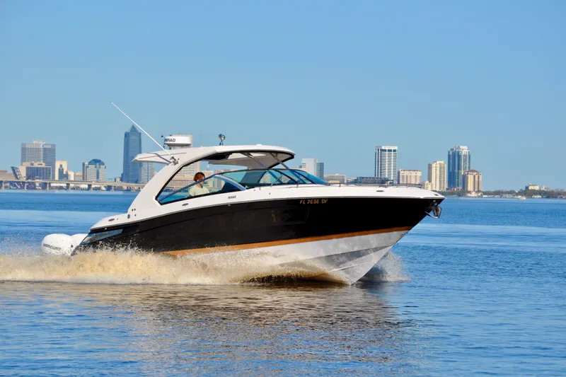  Yacht Photos Pics 2019 Four Winns H350 OB boat cruising on water with city skyline in background.