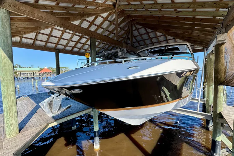  Yacht Photos Pics 2019 Four Winns H350 OB boat docked under a wooden shelter.