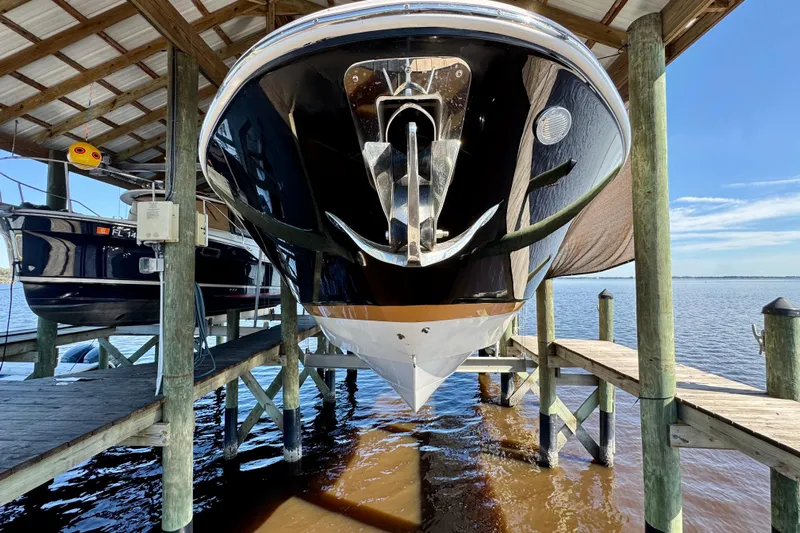  Yacht Photos Pics 2019 Four Winns H350 OB boat docked in a covered marina, viewed from the front.