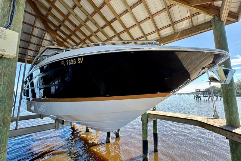  Yacht Photos Pics 2019 Four Winns H350 OB boat docked under a wooden shelter.