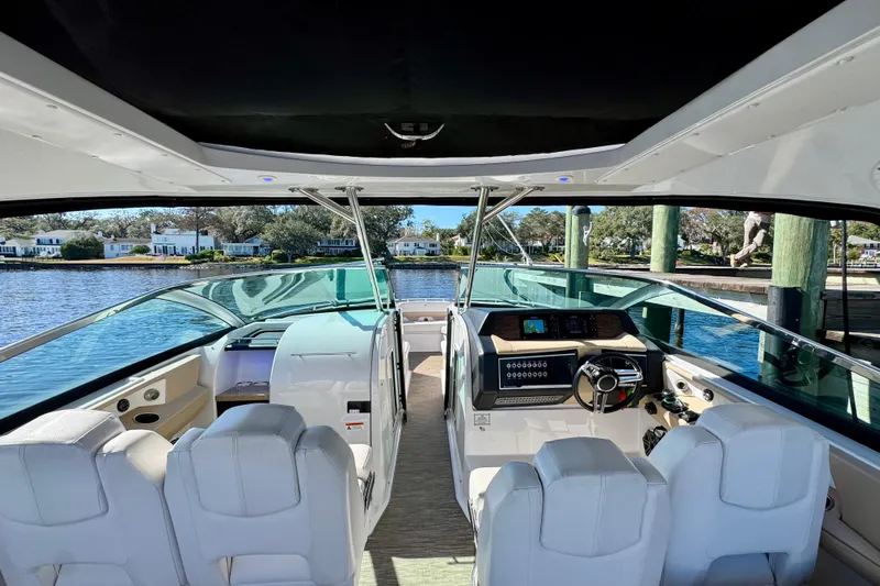  Yacht Photos Pics 2019 Four Winns H350 OB boat interior with modern dashboard and seating, docked by the water.
