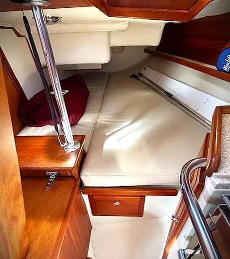 Last Dance Yacht Photos Pics Cozy interior cabin of 2019 Pacific Seacraft 31 sailboat with wooden accents and comfortable bedding.