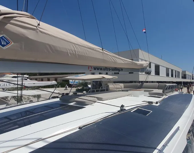  Yacht Photos Pics 2025 Fountaine Pajot Catamaran Aura 51 docked at marina under clear blue sky.