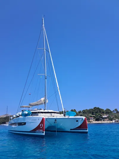  Yacht Photos Pics 2025 Fountaine Pajot Catamaran Aura 51 sailing in clear blue waters.