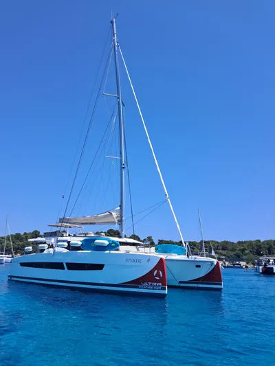 Yacht Photos Pics 2025 Fountaine Pajot Catamaran Aura 51 sailing on clear blue water.