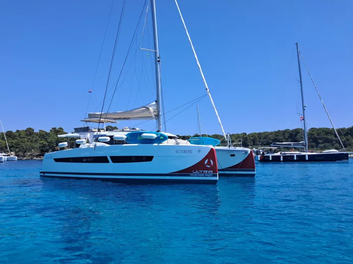  Yacht Photos Pics 2025 Fountaine Pajot Catamaran Aura 51 sailing in clear blue waters.