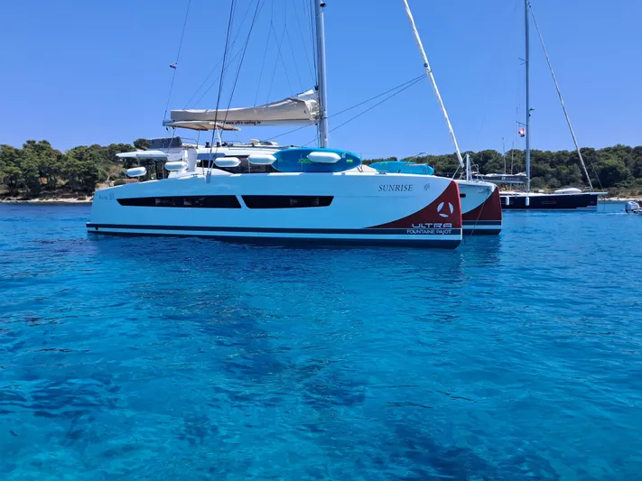  Yacht Photos Pics 2025 Fountaine Pajot Catamaran Aura 51 sailing on clear blue waters.