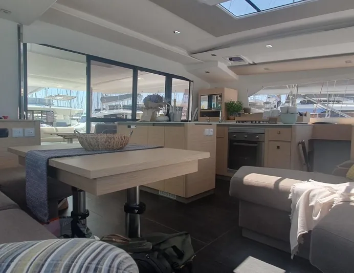  Yacht Photos Pics Luxurious interior of 2025 Fountaine Pajot Catamaran Aura 51 with modern kitchen and seating area.