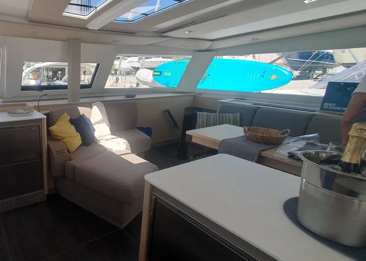  Yacht Photos Pics Luxurious interior of 2025 Fountaine Pajot Catamaran Aura 51 with modern seating and large windows.