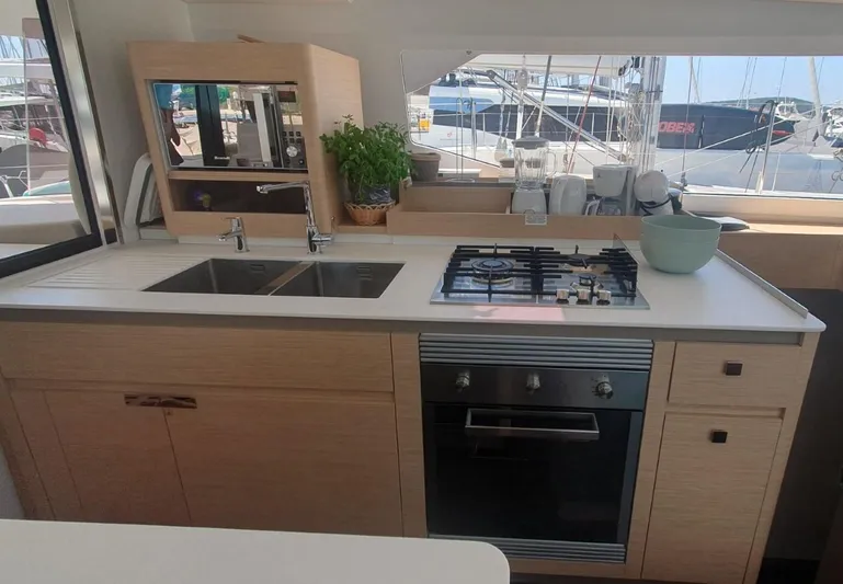  Yacht Photos Pics Modern kitchen in 2025 Fountaine Pajot Catamaran Aura 51 with stove, sink, and appliances.