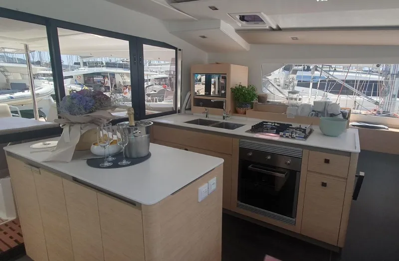  Yacht Photos Pics Luxurious kitchen interior of 2025 Fountaine Pajot Catamaran Aura 51, featuring modern appliances and elegant decor.