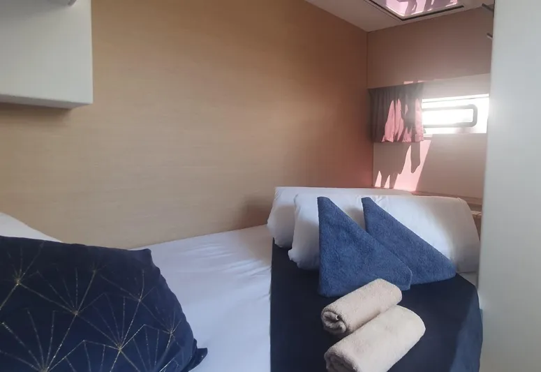  Yacht Photos Pics Luxurious cabin interior of 2025 Fountaine Pajot Catamaran Aura 51 with neatly arranged towels.