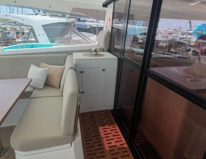  Yacht Photos Pics 2025 Fountaine Pajot Catamaran Aura 51 interior with seating and table, docked at marina.
