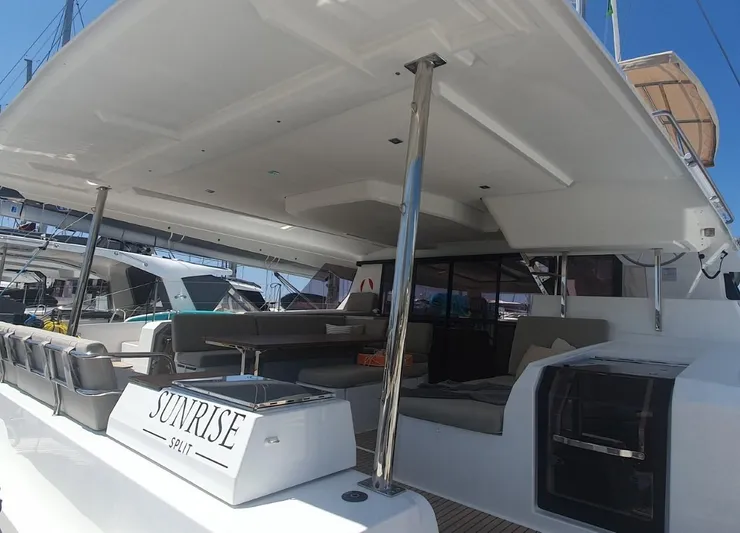  Yacht Photos Pics 2025 Fountaine Pajot Catamaran Aura 51, spacious deck with seating, docked at marina.