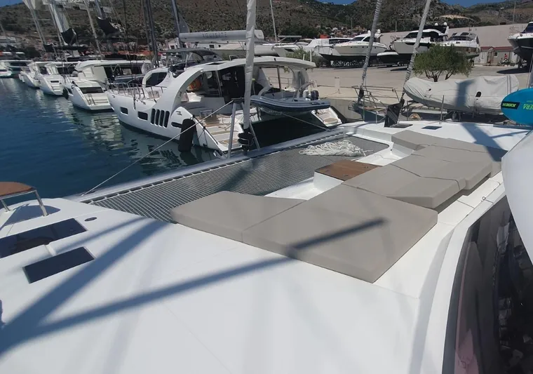  Yacht Photos Pics 2025 Fountaine Pajot Catamaran Aura 51 docked, featuring spacious deck and sunbathing area.