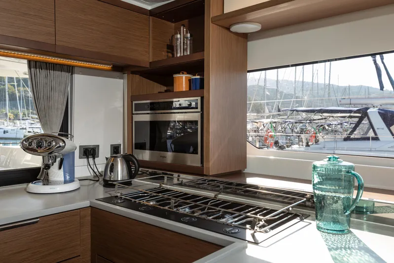 Twenty Cent Yacht Photos Pics Modern kitchen interior of 2021 Lagoon 46 yacht with appliances and marina view.