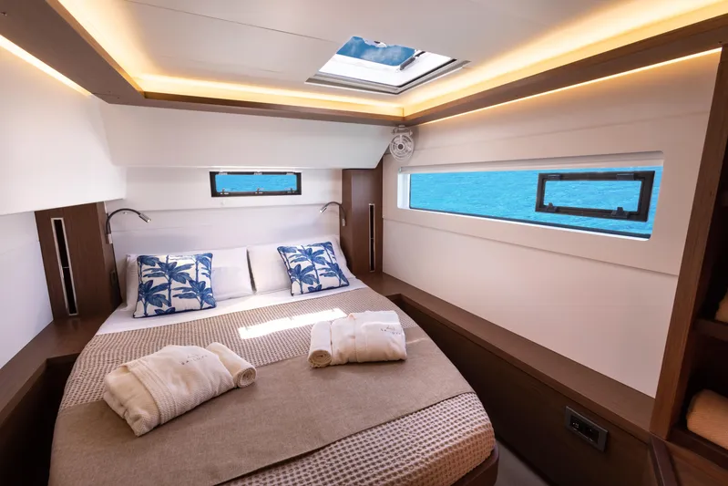 Twenty Cent Yacht Photos Pics Luxurious cabin interior of 2021 Lagoon 46 yacht with ocean view and elegant bedding.