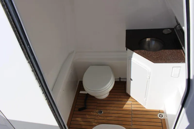  Yacht Photos Pics 2017 Buddy Davis 34 Center Console boat bathroom with wooden flooring and compact sink.