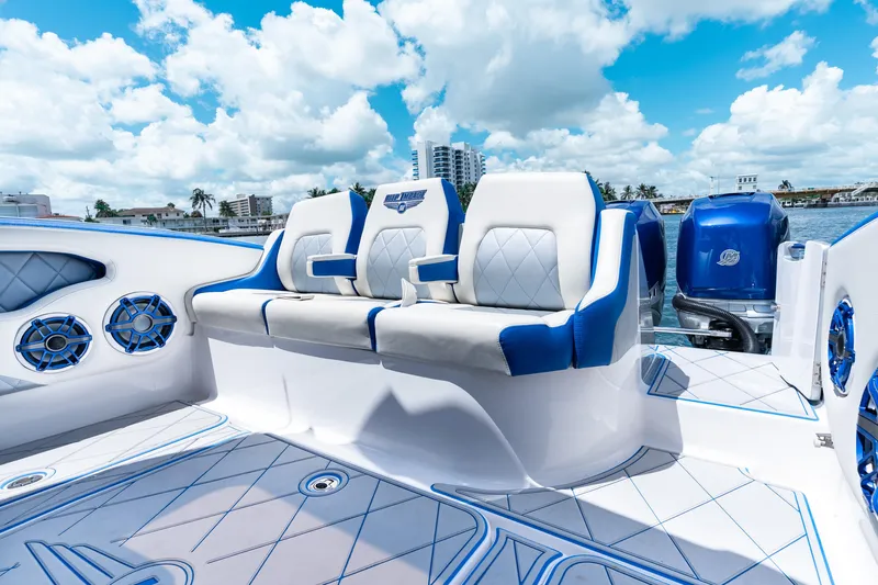  Yacht Photos Pics 2019 Deep Impact 399 Sport boat interior with blue and white seating, speakers, and ocean view.