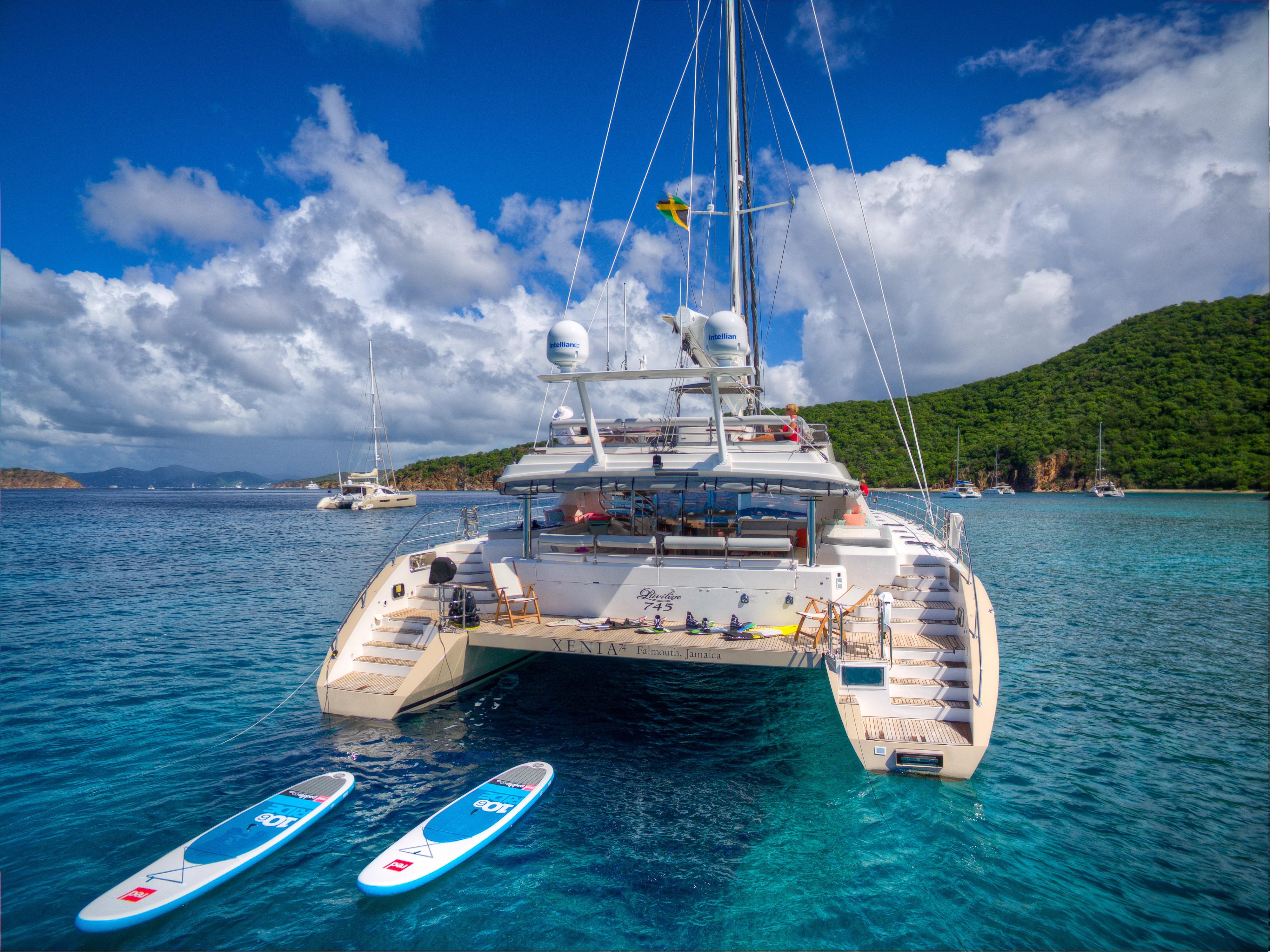 Luxury Privilege 745 yacht anchored in clear blue waters with paddleboards, 2010 model.
