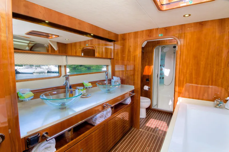  Yacht Photos Pics Luxurious bathroom on a 2010 Privilege 745 yacht with glass sinks and wooden finishes.