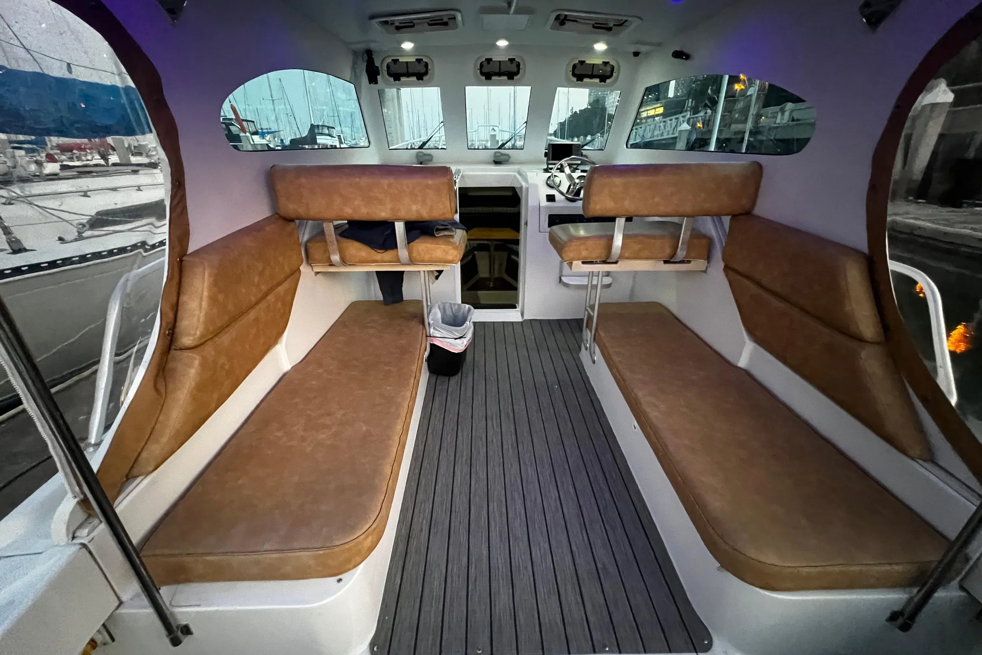Interior of 1999 Mainship Pilot 30 boat with brown seating and modern dashboard.