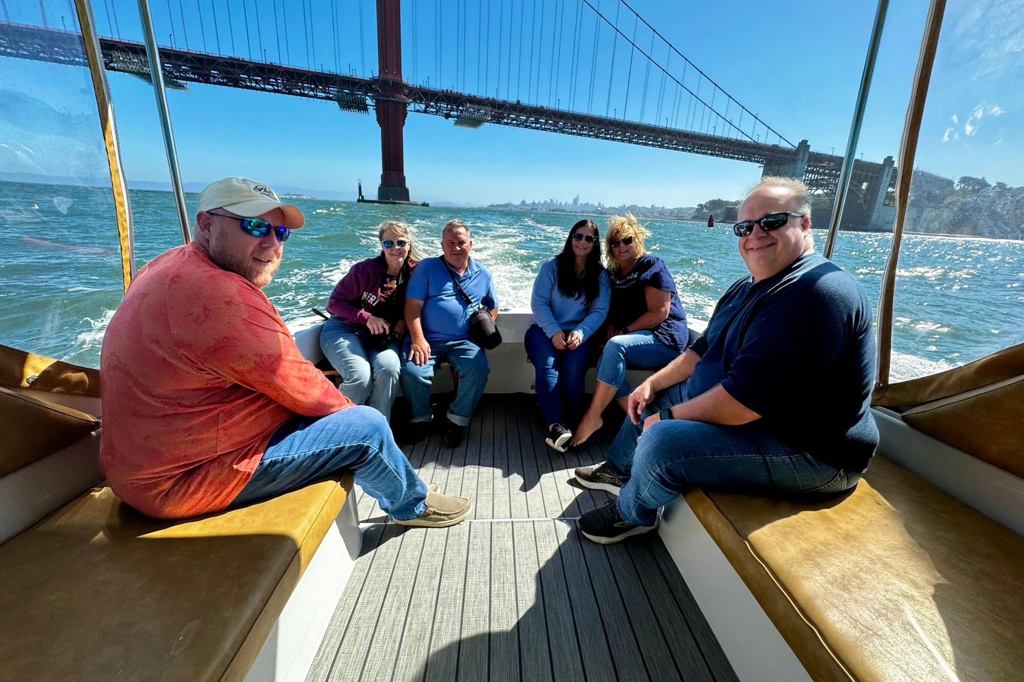 Group enjoying a boat ride on a 1999 Mainship Pilot 30 under the Golden Gate Bridge.