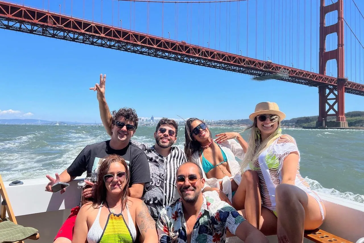 Group enjoying a boat ride on a 1999 Mainship Pilot 30 under the Golden Gate Bridge.