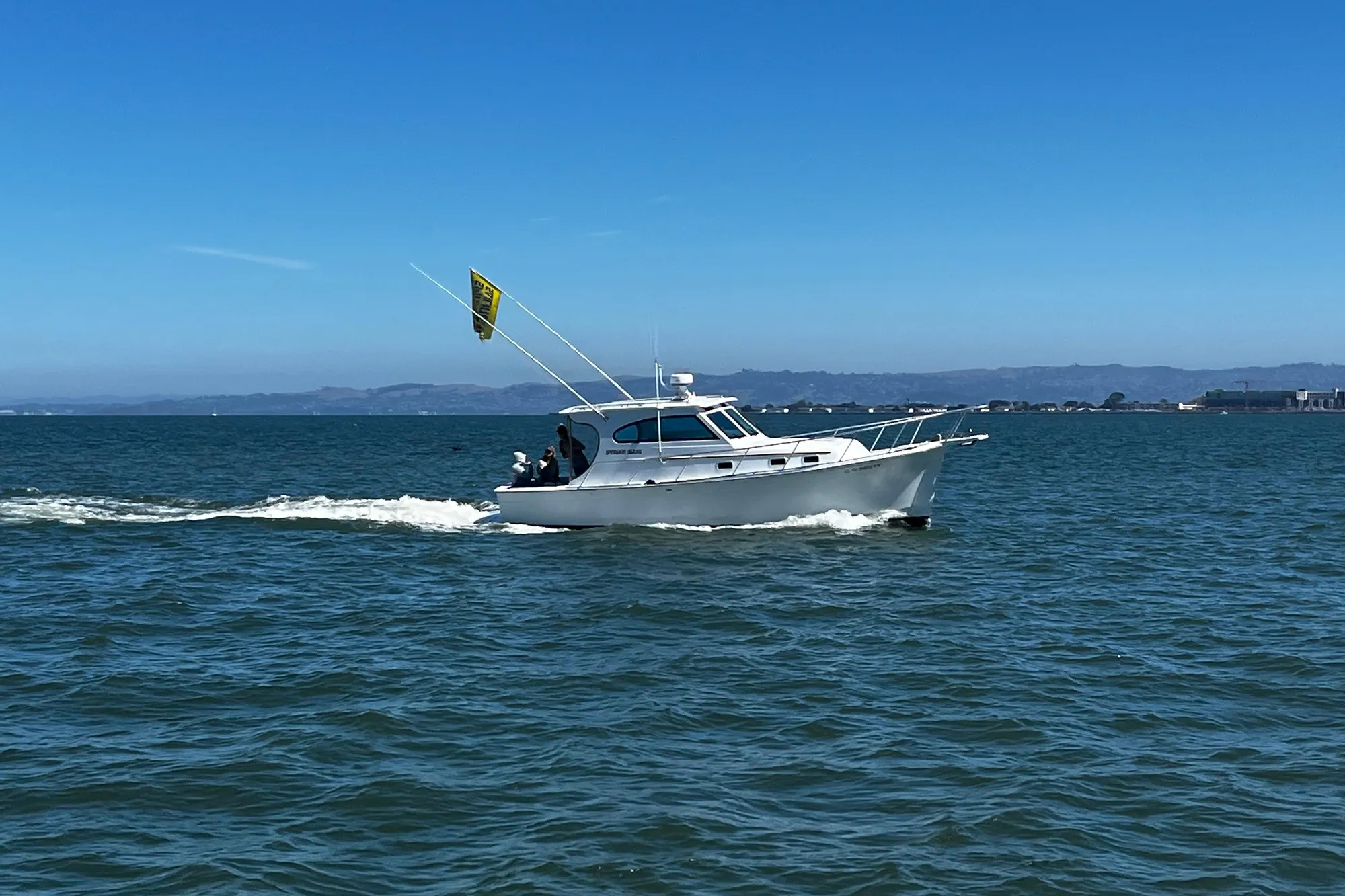 1999 Mainship Pilot 30 cruising on open water under clear blue skies.