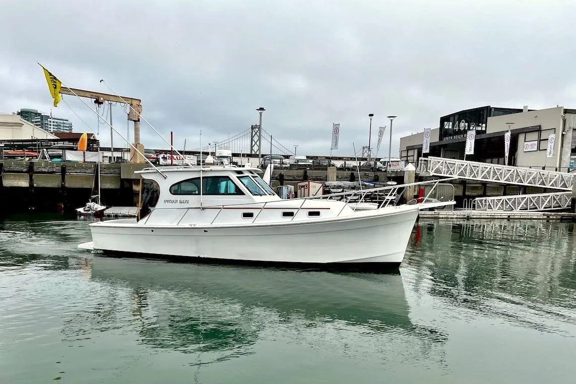 1999 Mainship Pilot 30 boat docked in a marina with overcast skies.