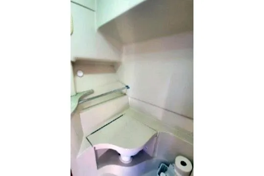 1999 Mainship Pilot 30 boat bathroom with compact sink and storage shelves.