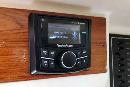 1999 Mainship Pilot 30 boat stereo system with Bluetooth connectivity displayed on wooden panel.
