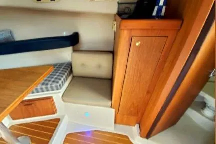 1999 Mainship Pilot 30 cabin interior with wood accents and seating area.