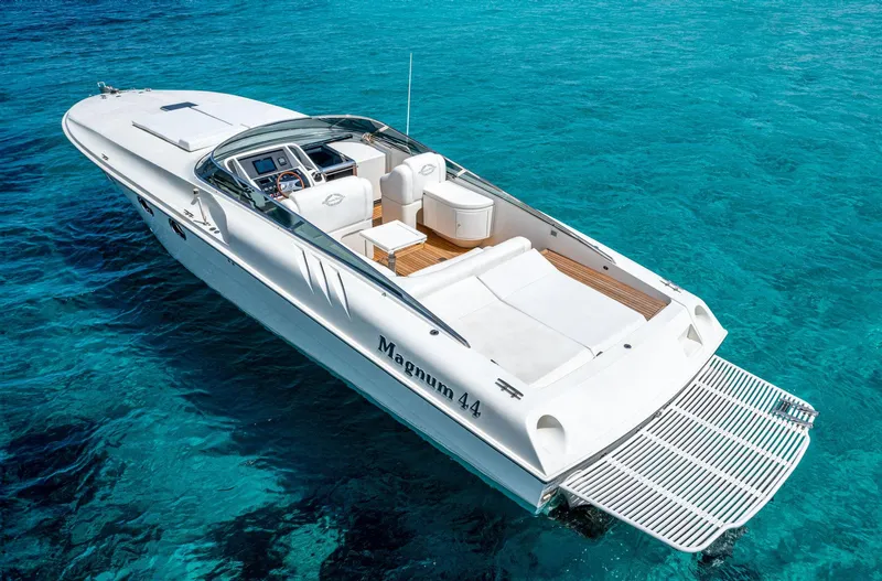 White Chocolate Yacht Photos Pics 2003 Magnum 44 boat on clear blue water, showcasing sleek design and spacious deck.