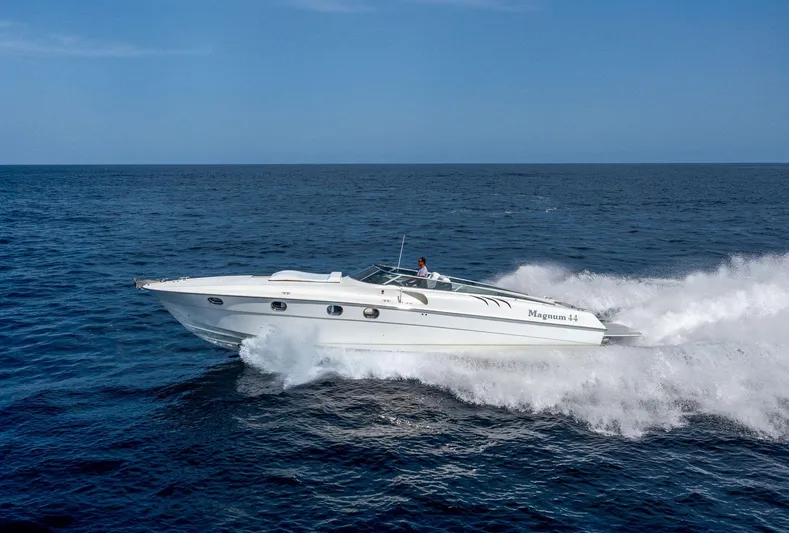 White Chocolate Yacht Photos Pics 2003 Magnum 44 speedboat cruising on open sea under clear blue sky.