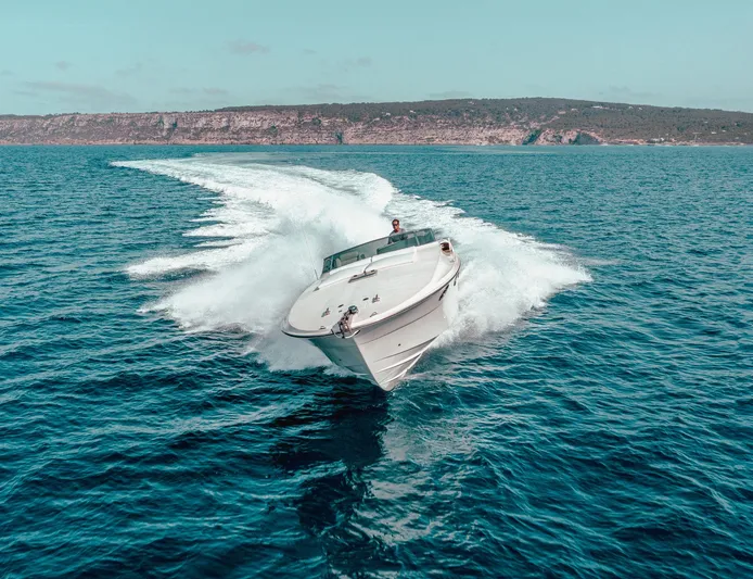 White Chocolate Yacht Photos Pics A 2003 Magnum 44 speedboat cruising on open water with a scenic coastline backdrop.