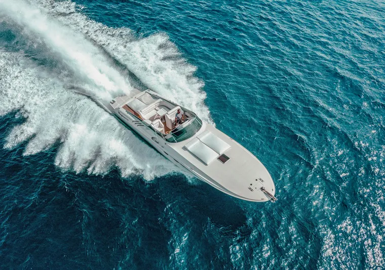 White Chocolate Yacht Photos Pics Aerial view of 2003 Magnum 44 speedboat cruising on blue ocean waters.