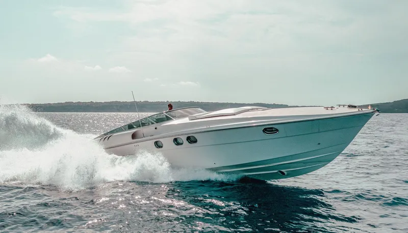 White Chocolate Yacht Photos Pics 2003 Magnum 44 yacht cruising on open water, creating waves.