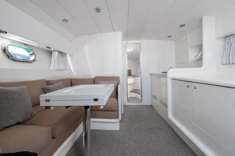 White Chocolate Yacht Photos Pics Interior of a 2003 Magnum 44 yacht with modern white furnishings and cozy seating area.