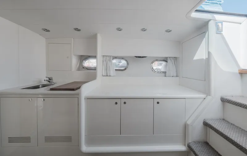 White Chocolate Yacht Photos Pics Interior of 2003 Magnum 44 yacht with modern white cabinetry and porthole windows.