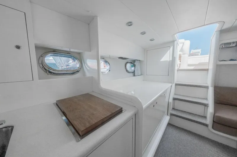 White Chocolate Yacht Photos Pics Interior of 2003 Magnum 44 yacht with modern white design and porthole windows.