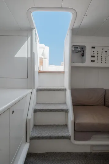 White Chocolate Yacht Photos Pics Interior of 2003 Magnum 44 yacht with stairs, control panel, and seating area.