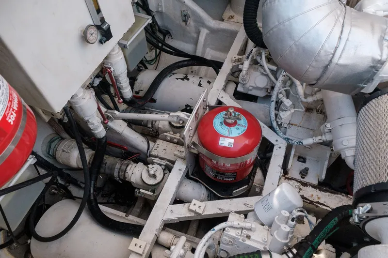 White Chocolate Yacht Photos Pics Engine room of a 2003 Magnum 44 boat, featuring mechanical components and a fire extinguisher.