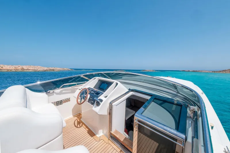 White Chocolate Yacht Photos Pics Luxury Magnum 44 yacht, 2003 model, cruising on clear blue waters under a sunny sky.