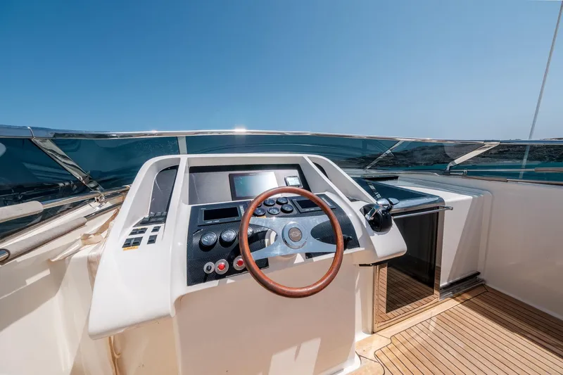 White Chocolate Yacht Photos Pics Helm of 2003 Magnum 44 yacht with wooden steering wheel and navigation controls.